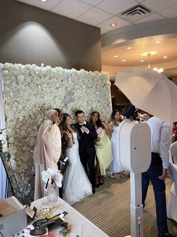 Guests at a luxury white floral wall booth